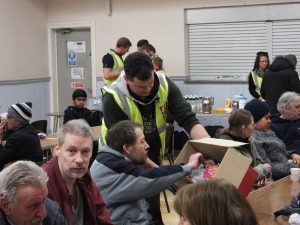 RRT member handing round food to hungry residents